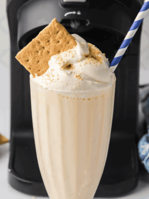 Ninja Creami vanilla milkshake in glass topped with whipped cream and cherry, McDonald’s copycat style.