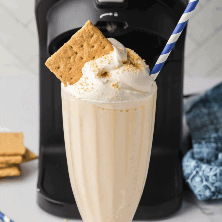 Ninja Creami vanilla milkshake in glass topped with whipped cream and cherry, McDonald’s copycat style.