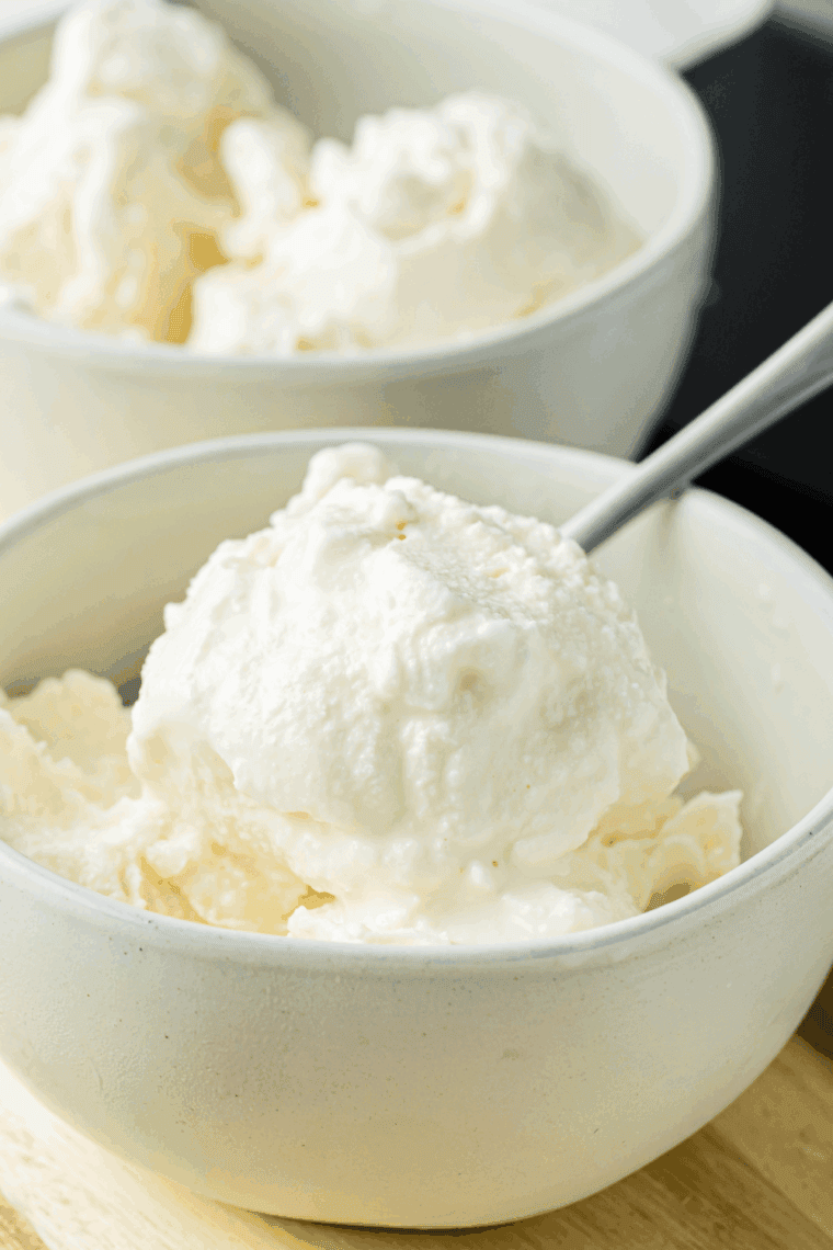 Creamy Ninja Creami vanilla almond ice cream topped with sliced almonds in a white bowl