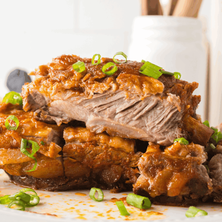 Juicy Korean BBQ ribs cooked in the Ninja Foodi and glazed with a sticky sauce on a serving plate.