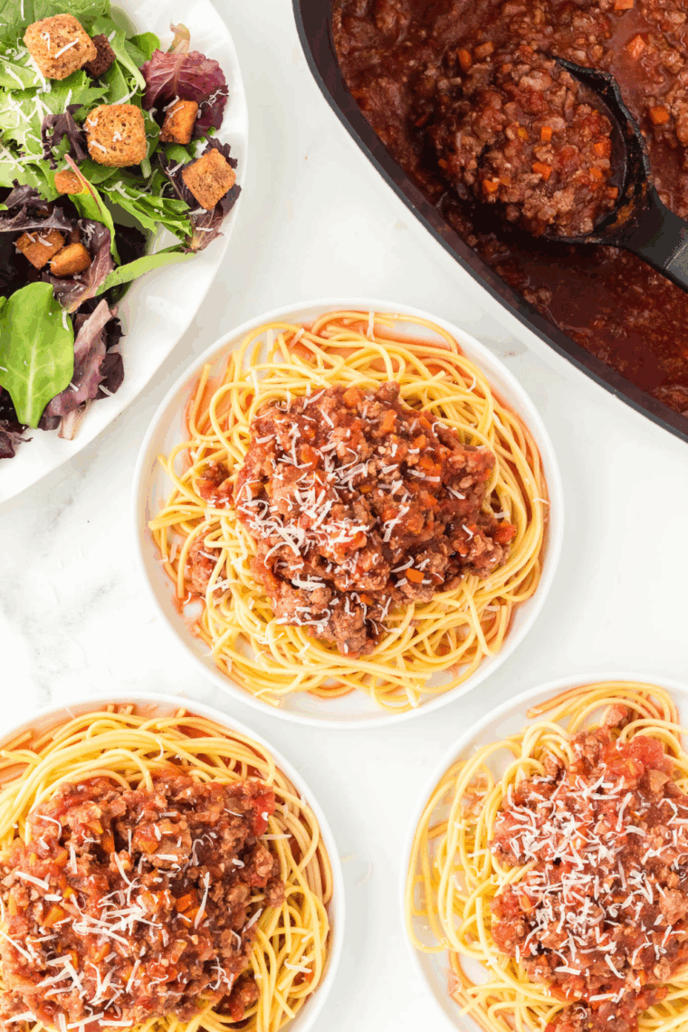 In Ninja Foodi Possible Cookware Pro, rich Bognese sauce is cooked with herbs on top and ready to be eaten on pasta.