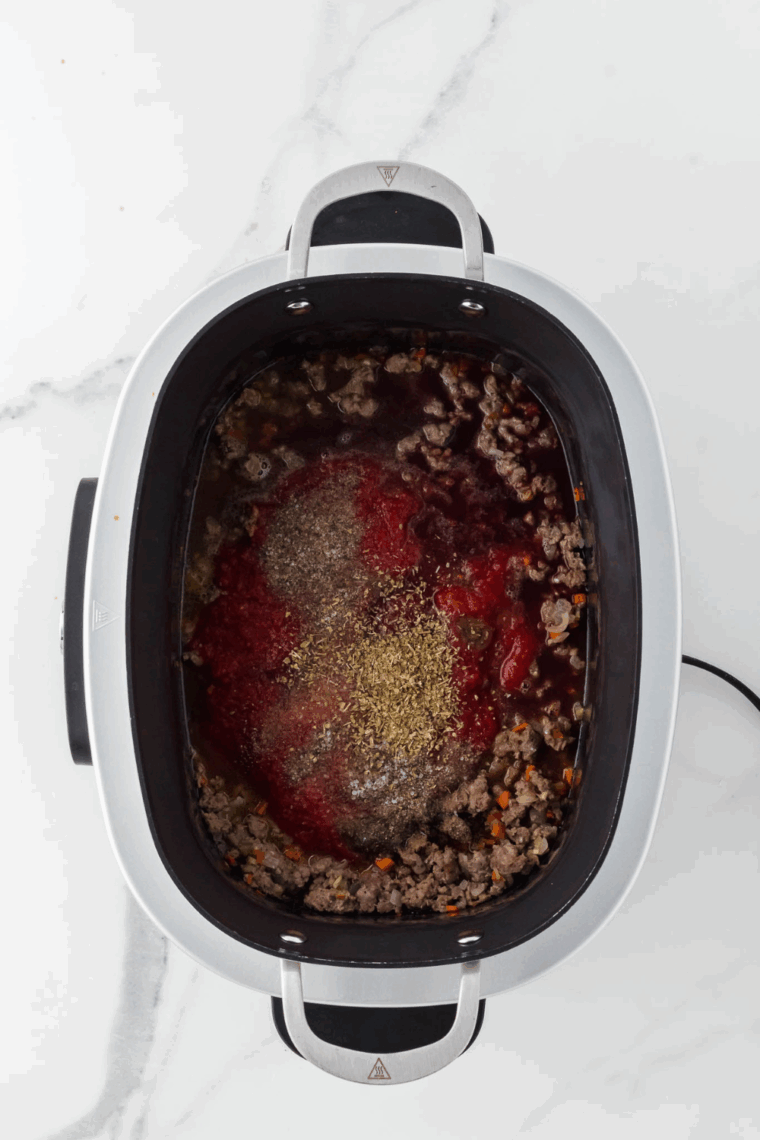 Stir in tomato sauce, whisk the crushed tomatoes, soup and seasonings into browned meat and vegetables.