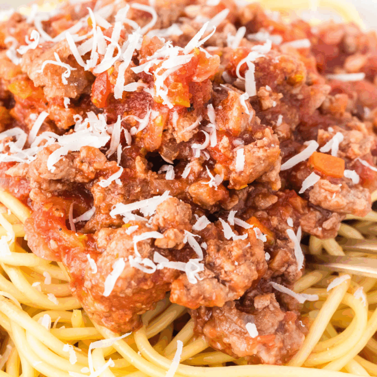 The hearty meat sauce boils in Ninja Foodi's possible Cooker Pro with herbs on top and served on a pasta bed.