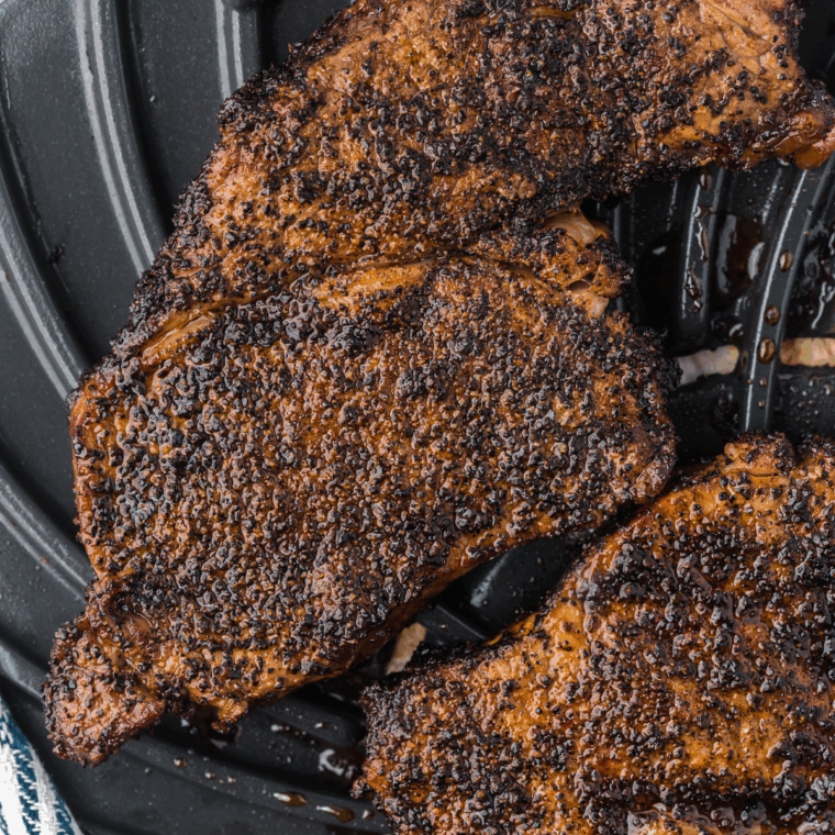 Homemade Outback Steak Seasoning blend in a white ramekin with surrounding spices and a spoon.