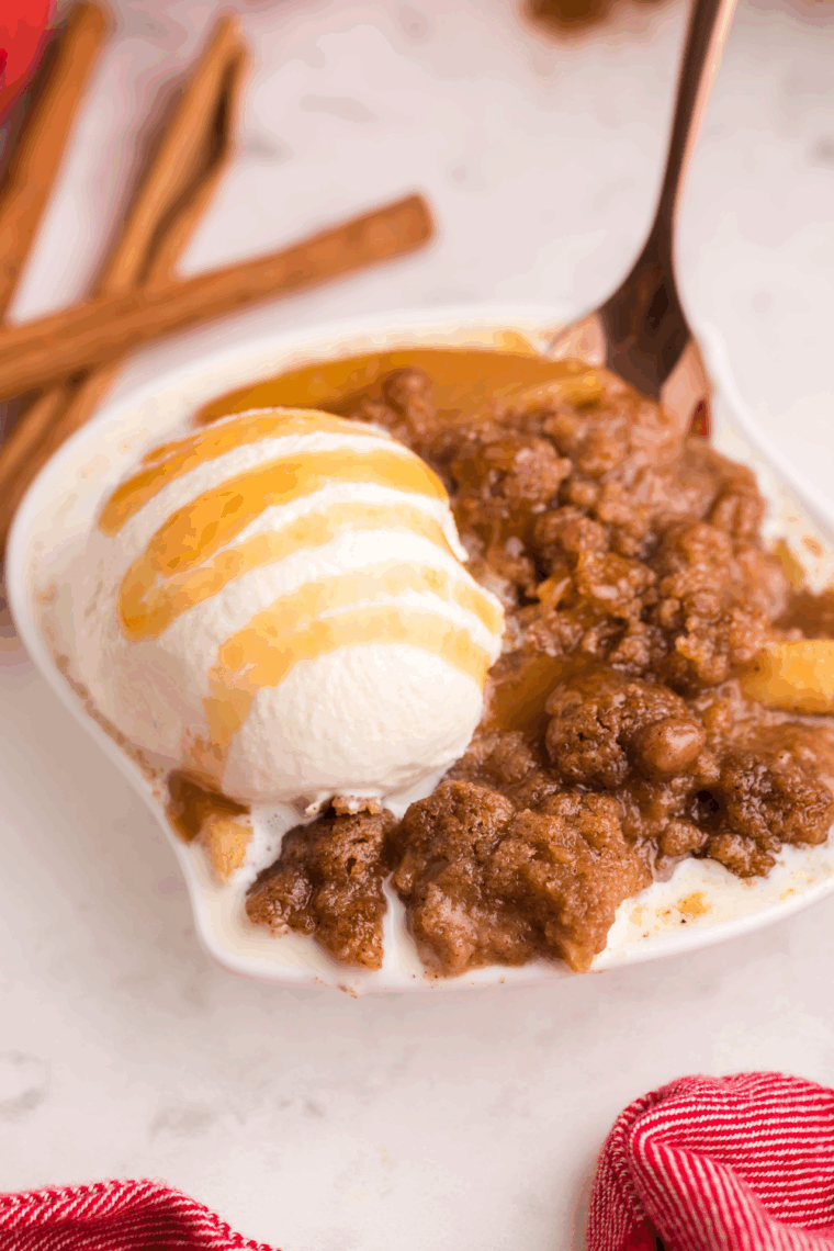 Warm cinnamon apples topped with crumble, vanilla ice cream, and caramel sauce—Outback Steakhouse Cinnamon Apple Oblivion served in a bowl.