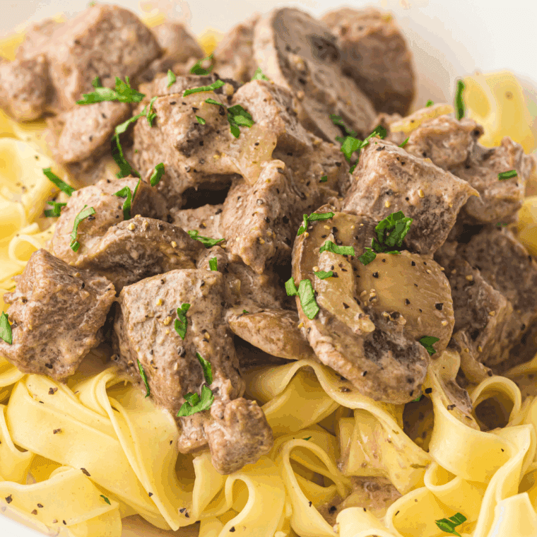 Slow Cooker Beef Stroganoff with tender beef, mushrooms, and creamy sauce served over egg noodles.