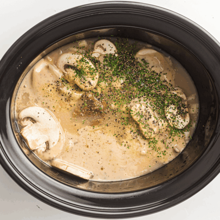 Sour cream being stirred into slow-cooked beef mixture.