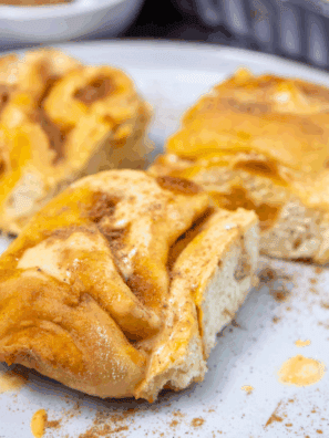 Fluffy sourdough pumpkin cinnamon rolls topped with creamy frosting.