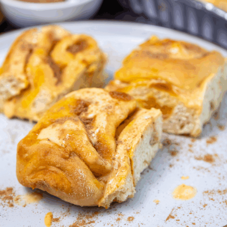Fluffy sourdough pumpkin cinnamon rolls topped with creamy frosting.
