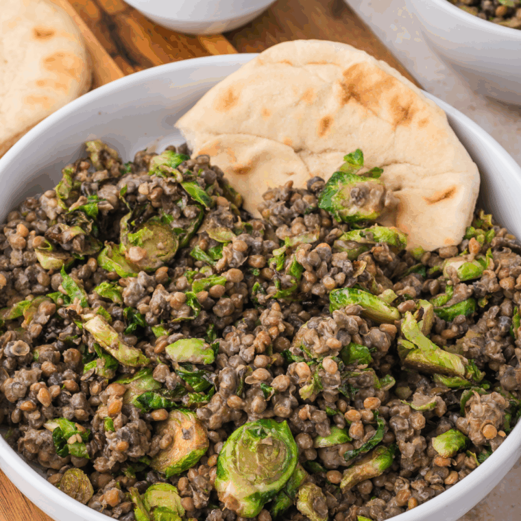 Bowl of Trader Joe's Sesame Brussels Sprouts and Lentil Salad with sesame dressing and fresh vegetables.