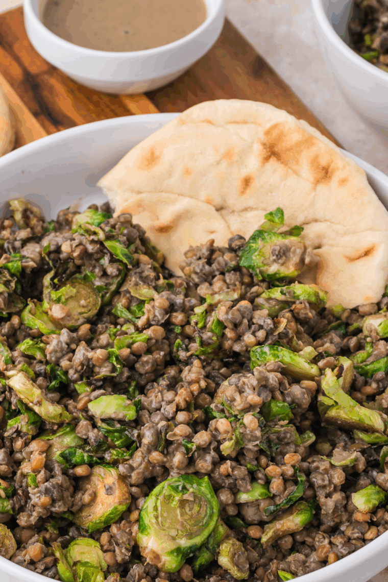 Bowl of Trader Joe’s Sesame Brussels Sprouts and Lentil Salad with sesame dressing drizzled on top.