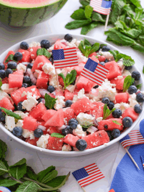 Bowl of fresh watermelon salad with feta cheese, mint leaves, and cucumber, perfect for a summer meal.