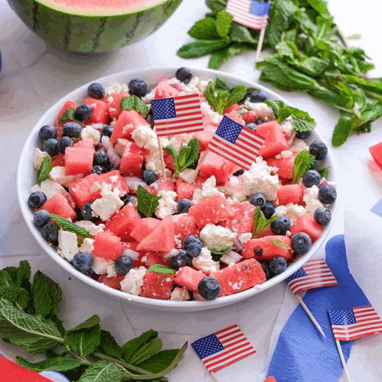 Bowl of fresh watermelon salad with feta cheese, mint leaves, and cucumber, perfect for a summer meal.
