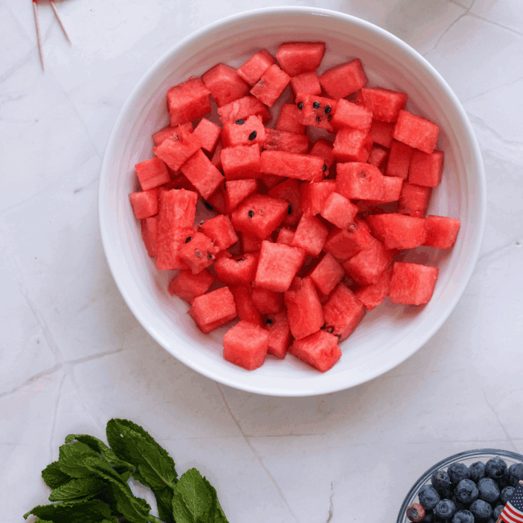 Cut watermelon in a large mixing bowl.