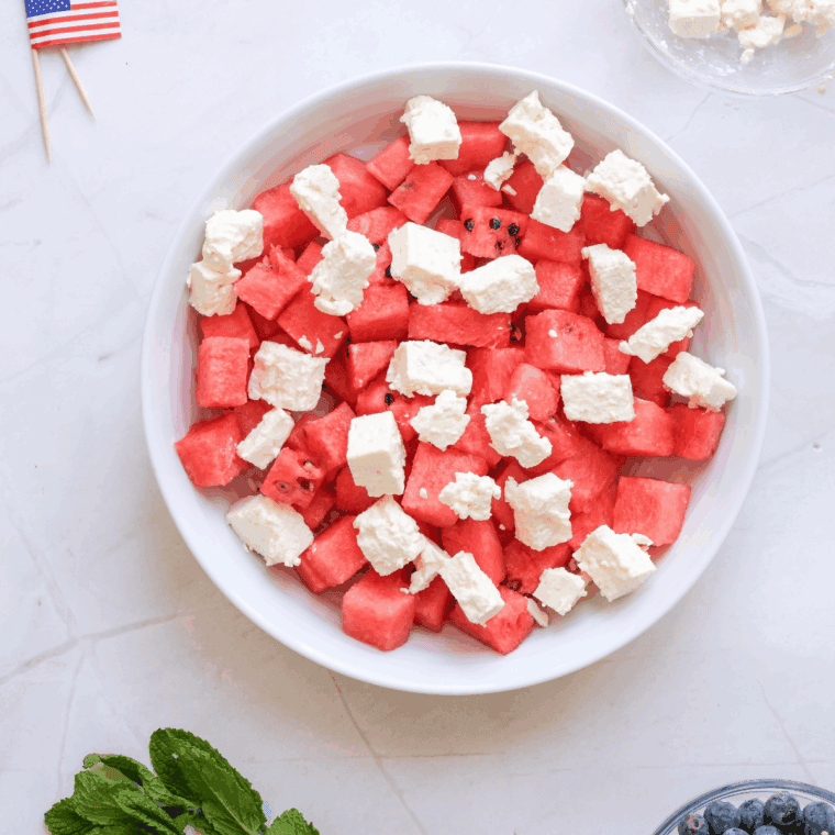 Diced watermelon with cut feta in a large mixing bowl.