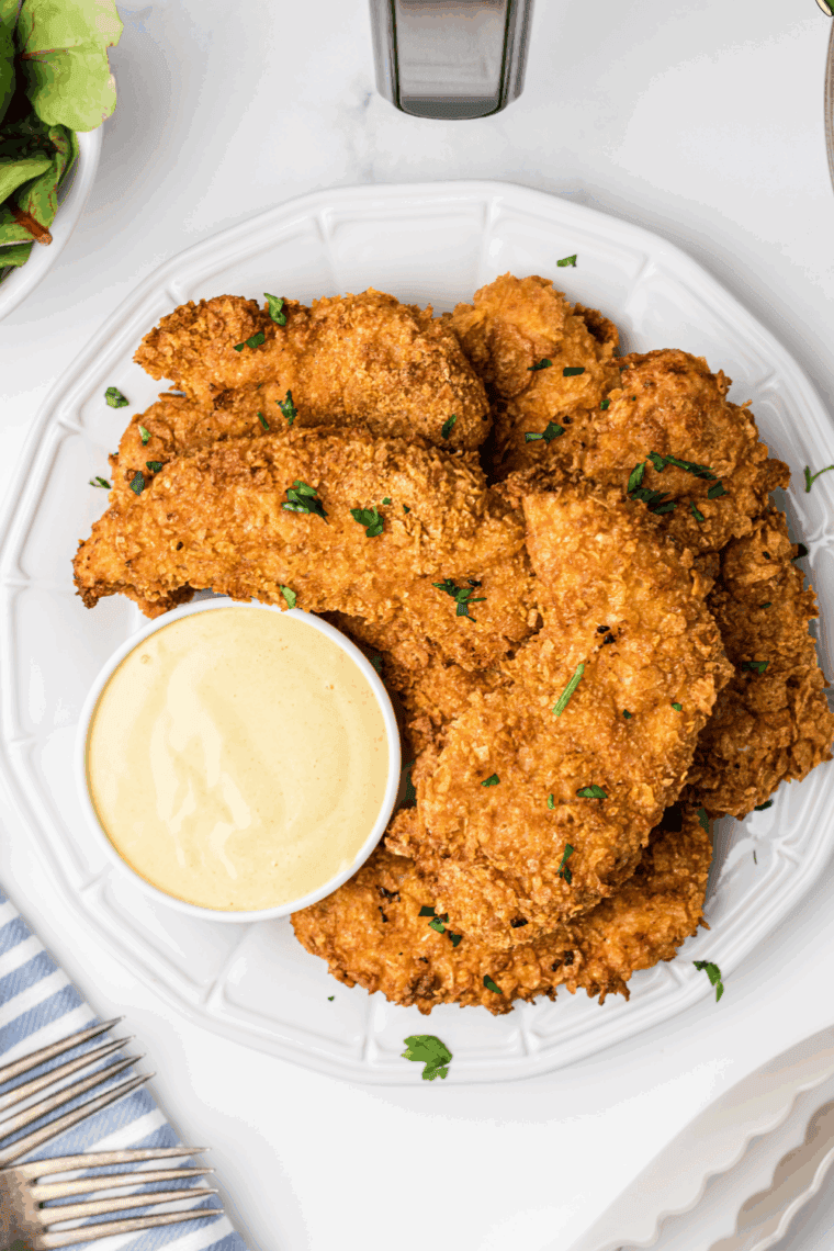 Homemade Arby’s Dijon Honey Mustard sauce in a small bowl with a spoon, ready for dipping fries and chicken tenders.