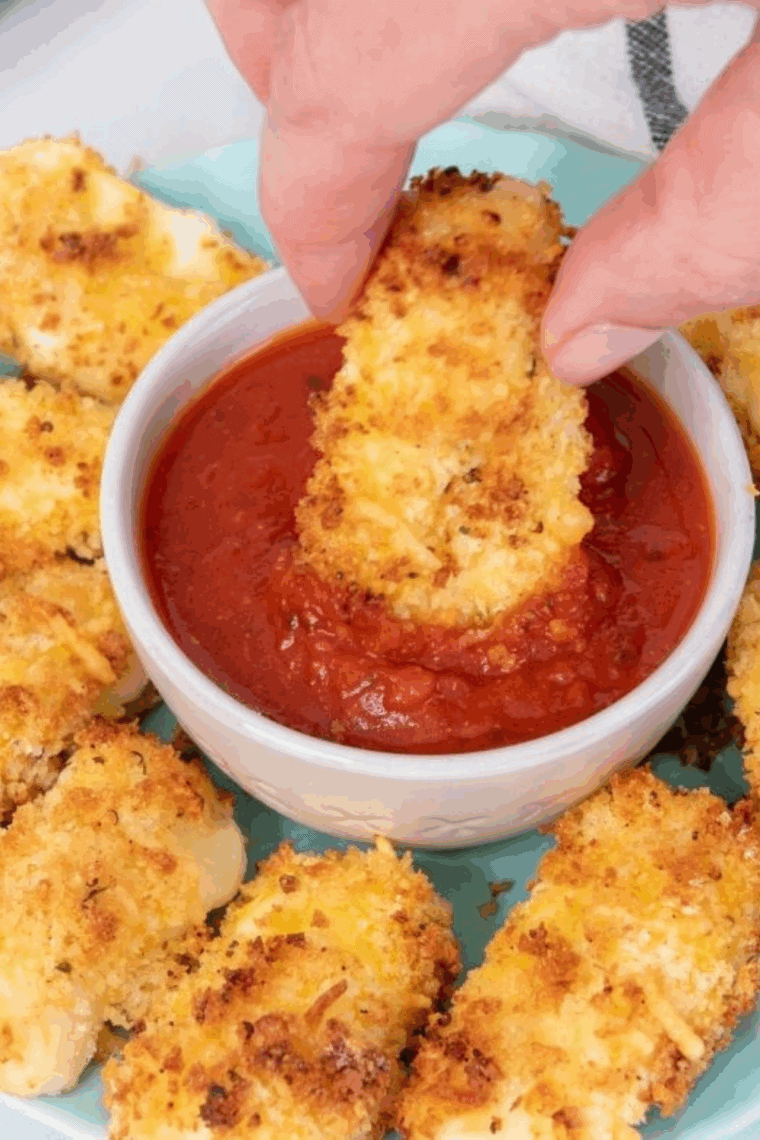 Homemade Arby’s marinara sauce served in a small bowl with mozzarella sticks.