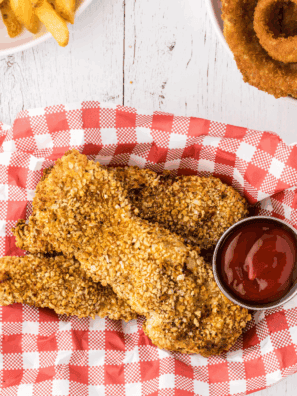 Plate of golden, crispy Arthur Treacher’s style fried chicken with dipping sauce.