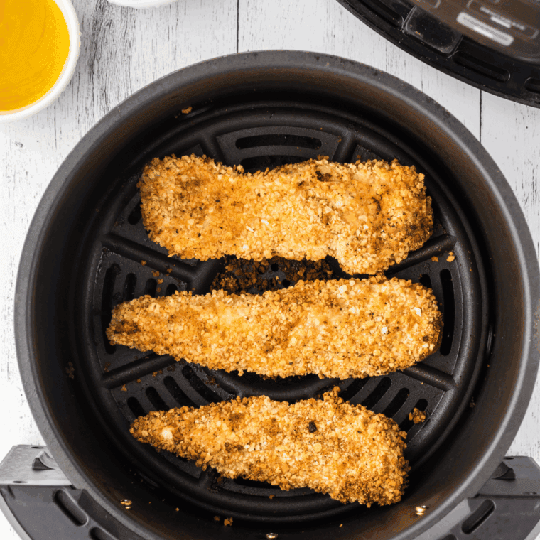 Golden brown air-fried chicken resting on a plate to lock in juices before serving.