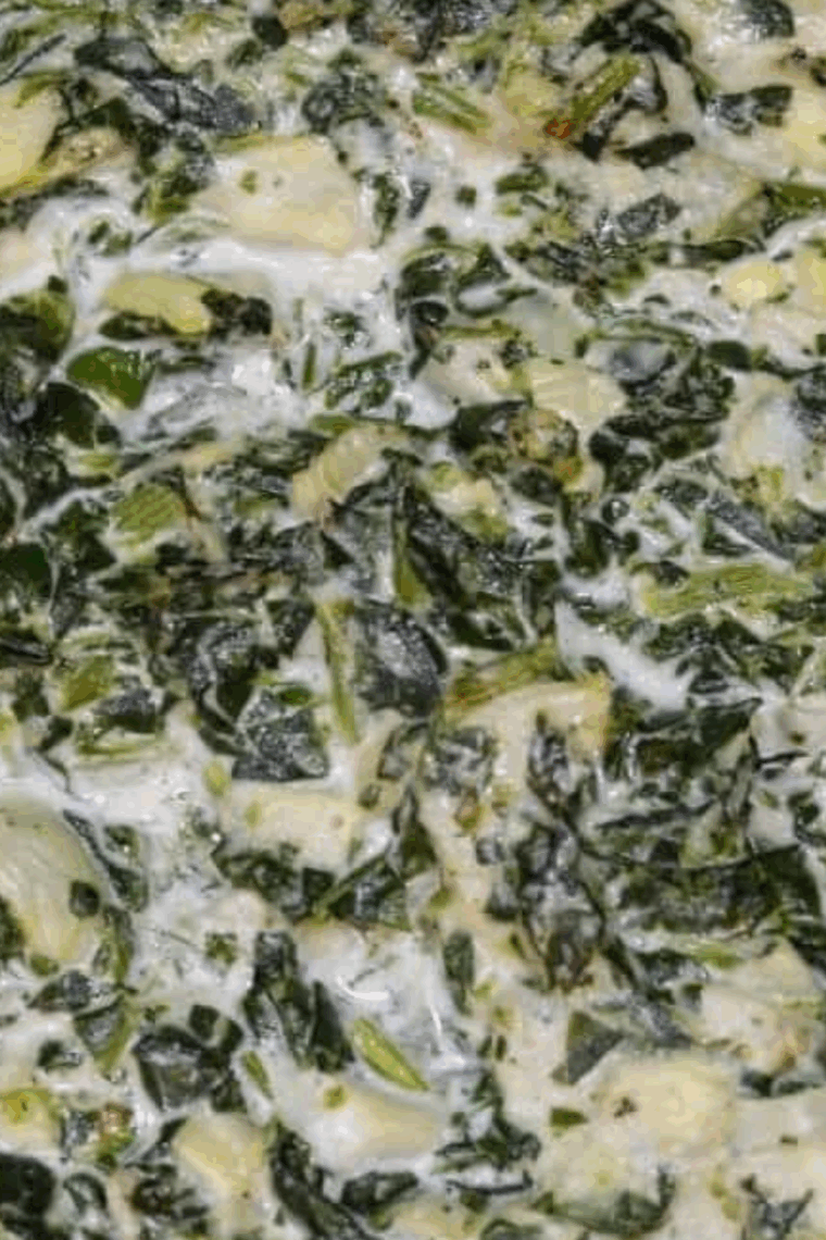Hot and creamy spinach artichoke dip in a baking dish with golden, melted cheese.