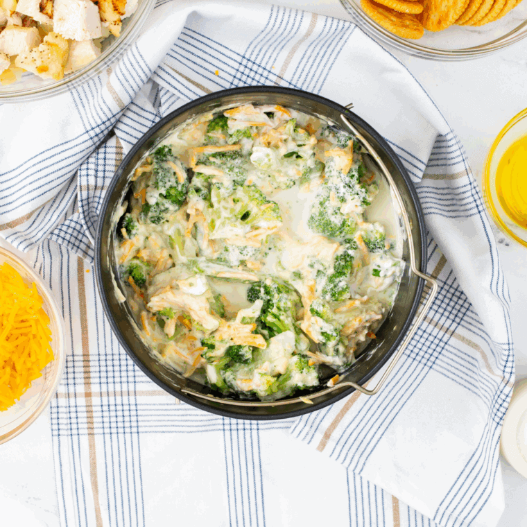 Preheating oven to 375°F and greasing a 9x13-inch baking dish; steaming broccoli until tender; mixing mayonnaise, sour cream, lemon juice, garlic powder, salt, and pepper into a creamy sauce.