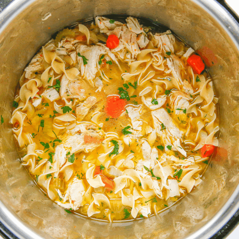 Soup simmering in Instant Pot on Sauté mode with visible pasta cooking.