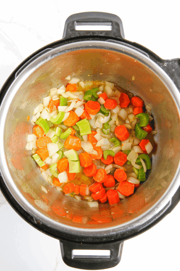 Sautéing onions, carrots, celery, and garlic in an Instant Pot for soup base.