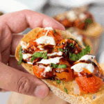Plated Carrabba’s Tomato Caprese with creamy burrata, sliced tomatoes, fresh basil, and balsamic glaze drizzle.