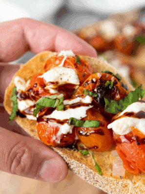 Plated Carrabba’s Tomato Caprese with creamy burrata, sliced tomatoes, fresh basil, and balsamic glaze drizzle.
