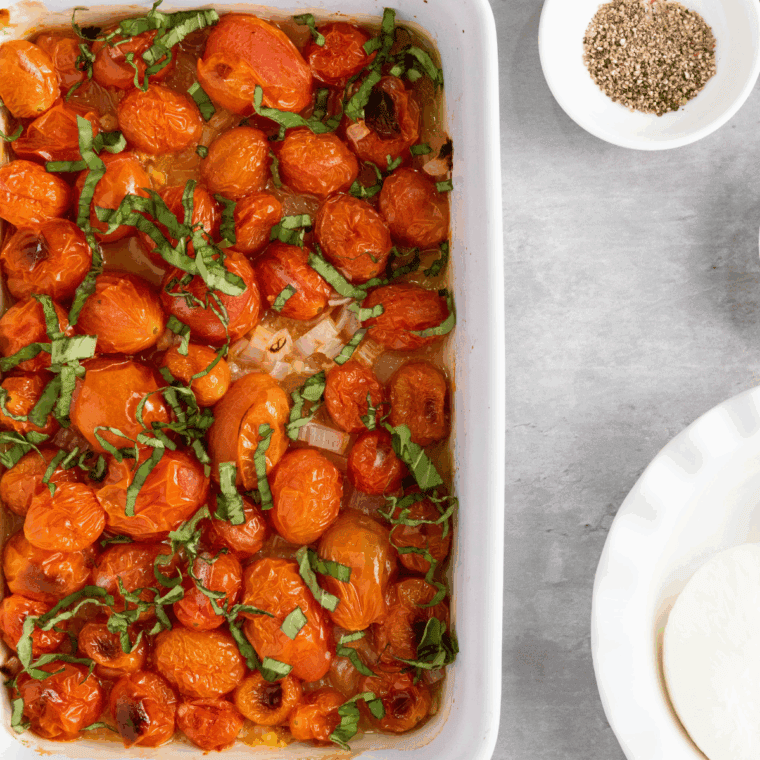 Roasted cherry tomatoes bursting with juices in the oven.