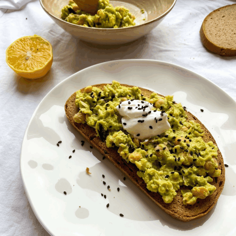 Homemade Cheesecake Factory-style avocado toast topped with fresh tomatoes and microgreens
