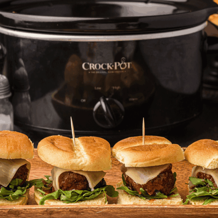 Golden baked meatball sliders brushed with garlic butter and sprinkled with Parmesan cheese.