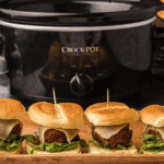 Tray of Cheesecake Factory-style meatball sliders with marinara and melted mozzarella on slider buns