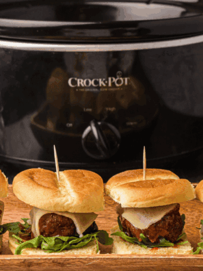Tray of Cheesecake Factory-style meatball sliders with marinara and melted mozzarella on slider buns