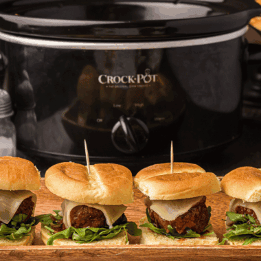 Tray of Cheesecake Factory-style meatball sliders with marinara and melted mozzarella on slider buns