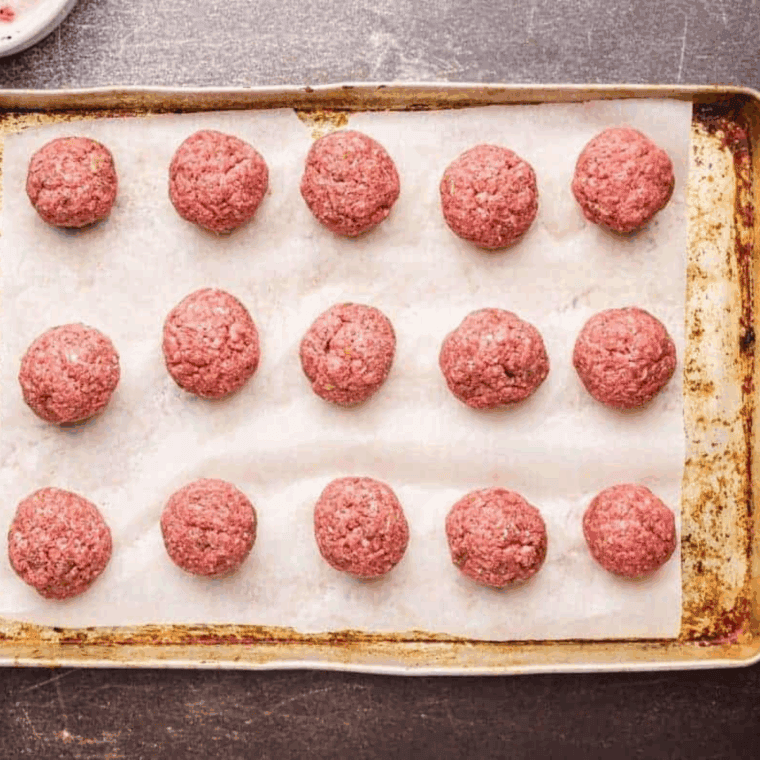 Raw meatballs rolled and placed in a slow cooker with marinara sauce poured over the top.
