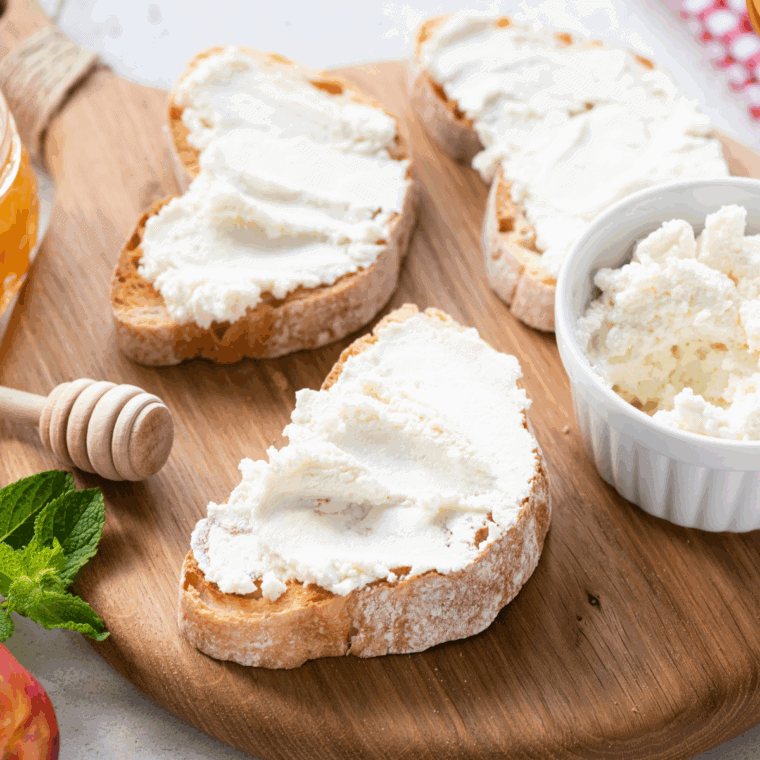 Spreading ricotta cheese on the cooked bread.