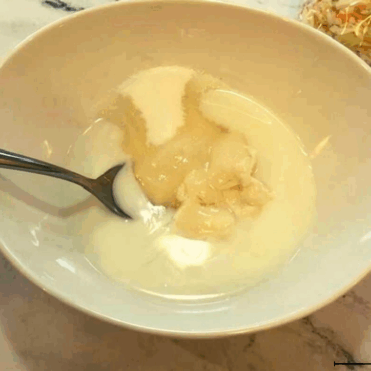 Whisking creamy coleslaw dressing made with mayo, vinegar, sugar, and mustard.