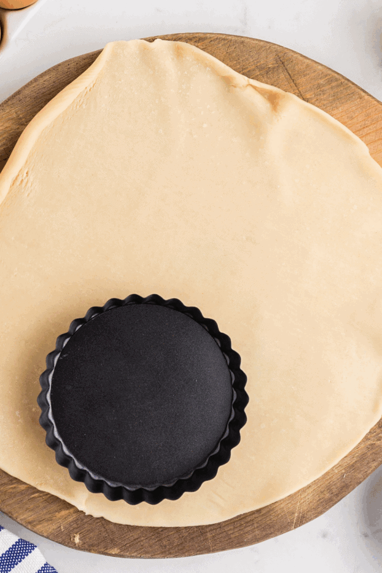 Cut the pie crust to form the quiche base.