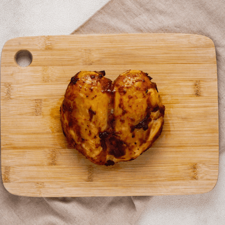 Cooked BBQ Chicken on Kitchen Cutting Board.