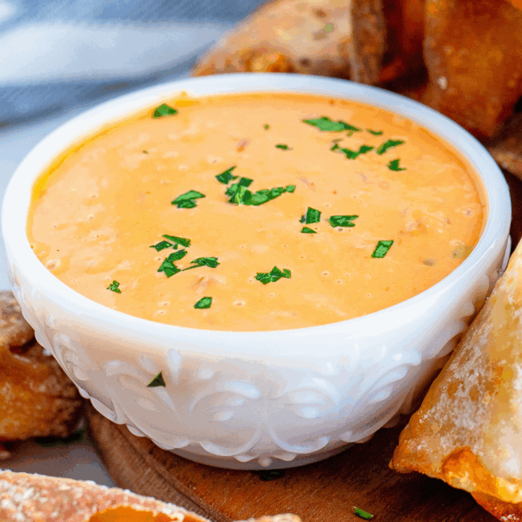 Creamy homemade dipping sauce served with blistered shishito peppers on a white plate