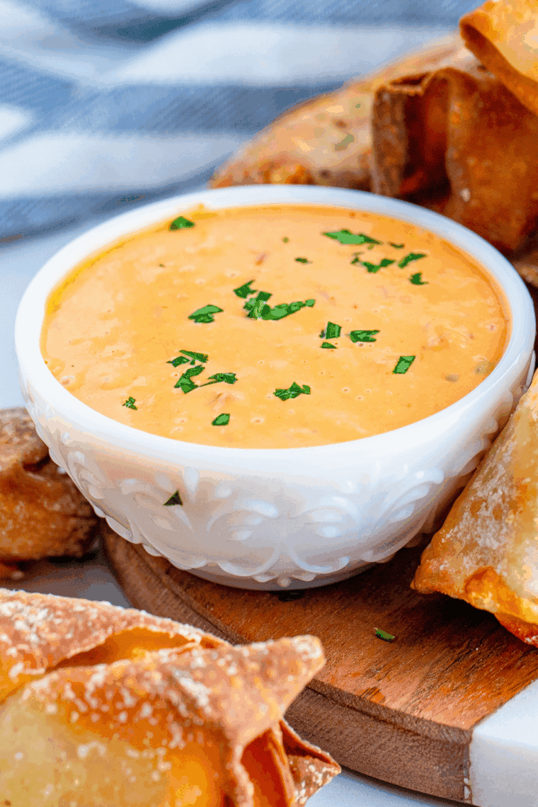 Blistered shishito peppers served with creamy homemade dipping sauce in a small bowl