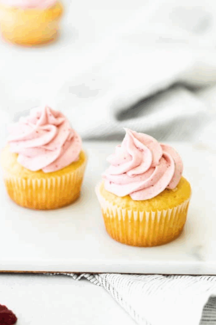 Close-up of creamy raspberry frosting made with fresh raspberries and jam on a cupcake.