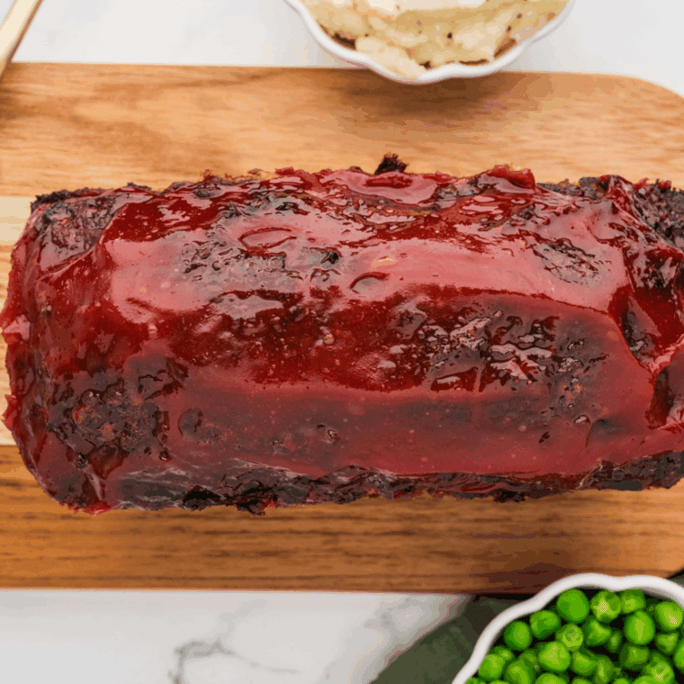 Juicy baked meatloaf topped with ketchup glaze in baking dish