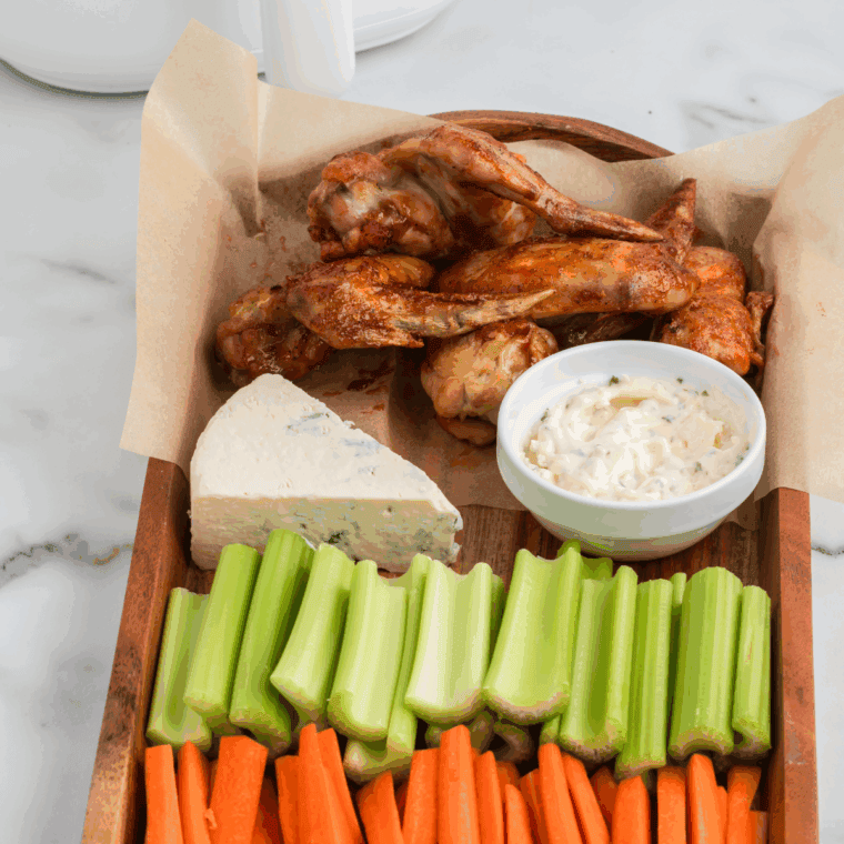Hooters Daytona wings copycat piled on a white plate with celery and blue cheese dip