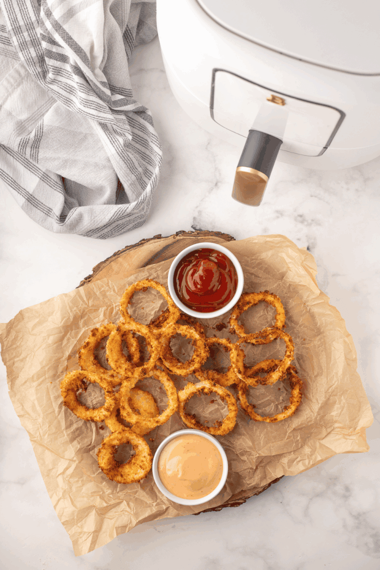 Plate of golden, crispy Hooters-style onion rings served with dipping sauce.