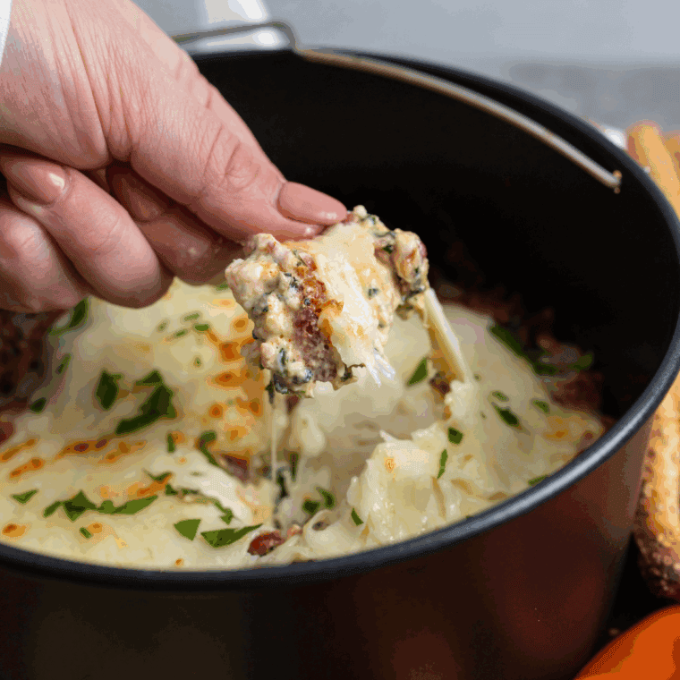 Bubbly spinach artichoke dip fresh from the oven with golden cheese on top.