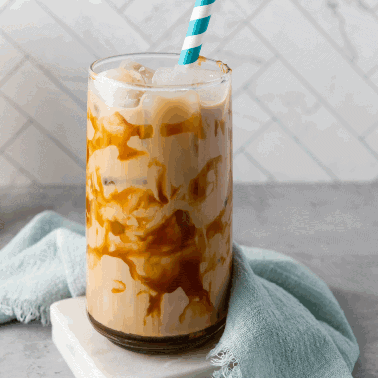 Glass of homemade Jack in the Box Creamaccino topped with whipped cream and caramel drizzle.