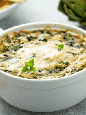 Homemade Longhorn Steakhouse copycat Parmesan Crusted Spinach Dip served in a skillet with golden cheese topping and chips for dipping.