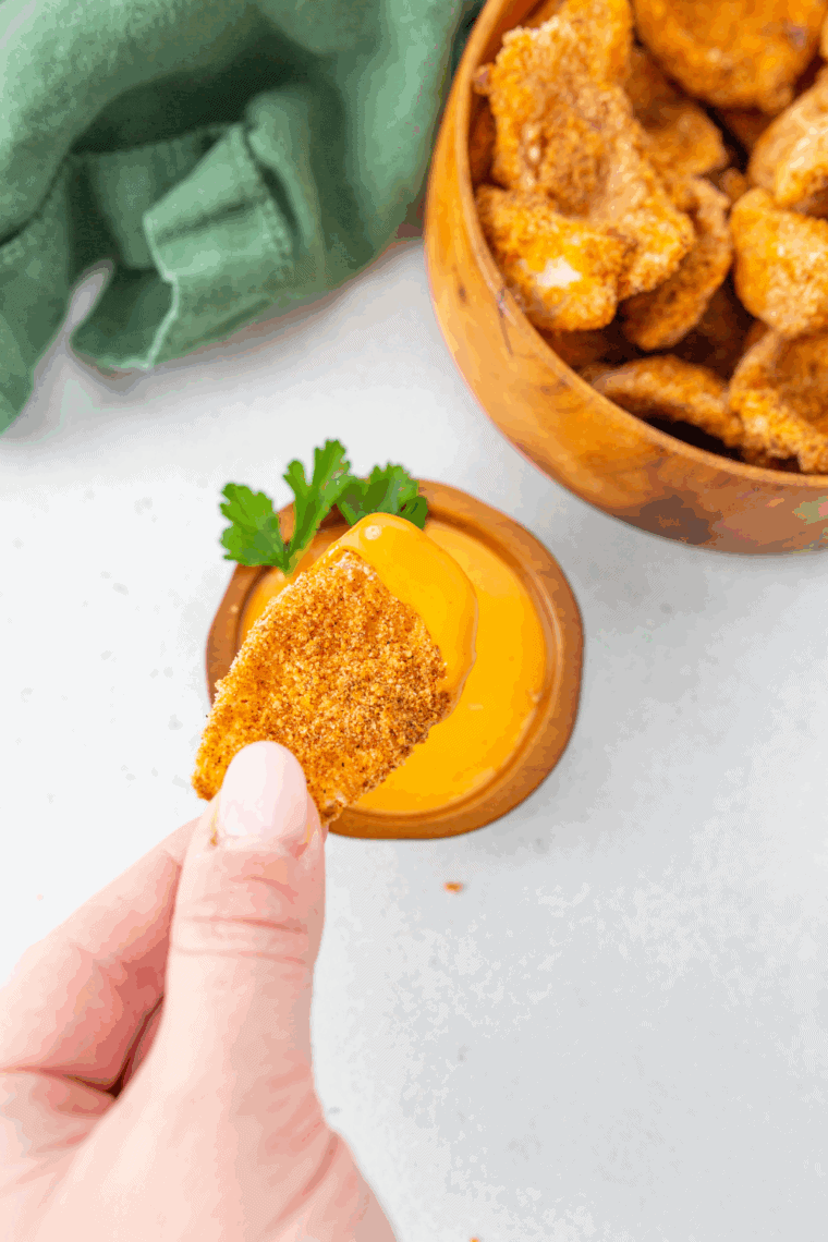 Longhorn Steakhouse-style Texas Tonion soaks seasoning in a small bowl with crispy onion petals.